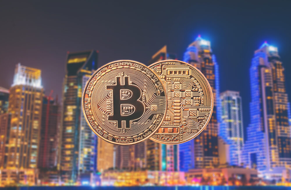 Bitcoin with Dubai city skyline illuminated at night.