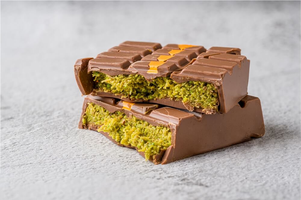 Close-up of a chocolate bar with a green pistachio filling.