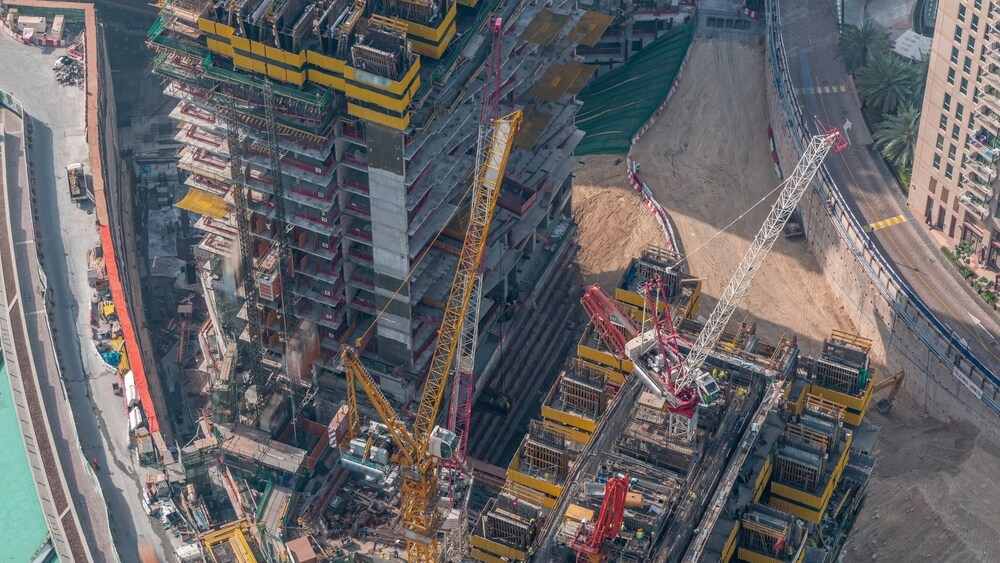 Aerial view of an active construction site with cranes and building structures.