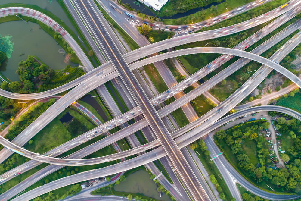 Aerial view of an intricate highway interchange with surrounding greenery.