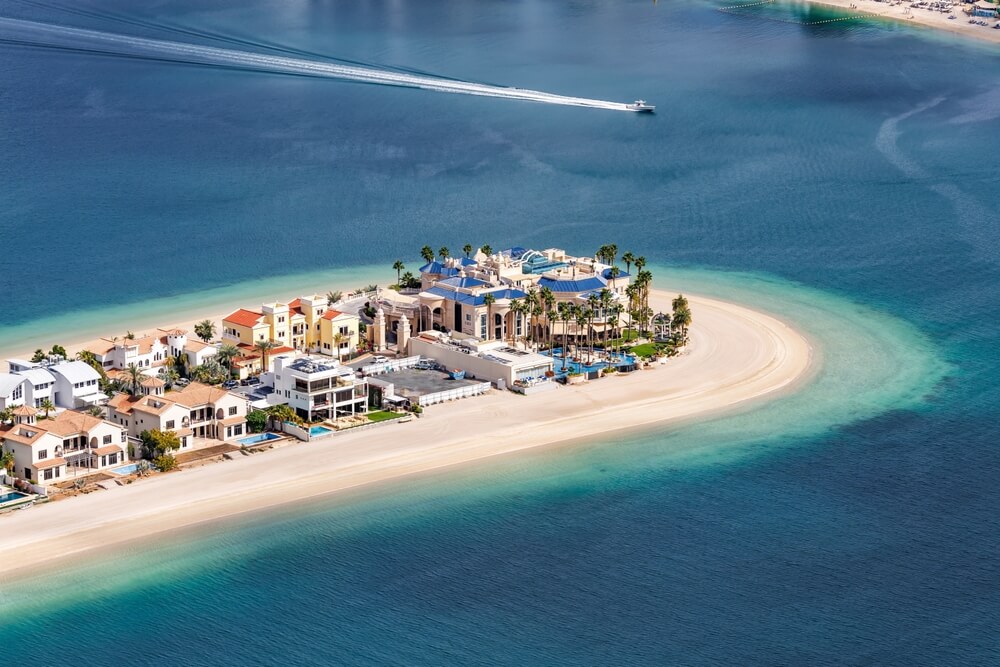 Manmade island with luxury villas surrounded by turquoise waters.